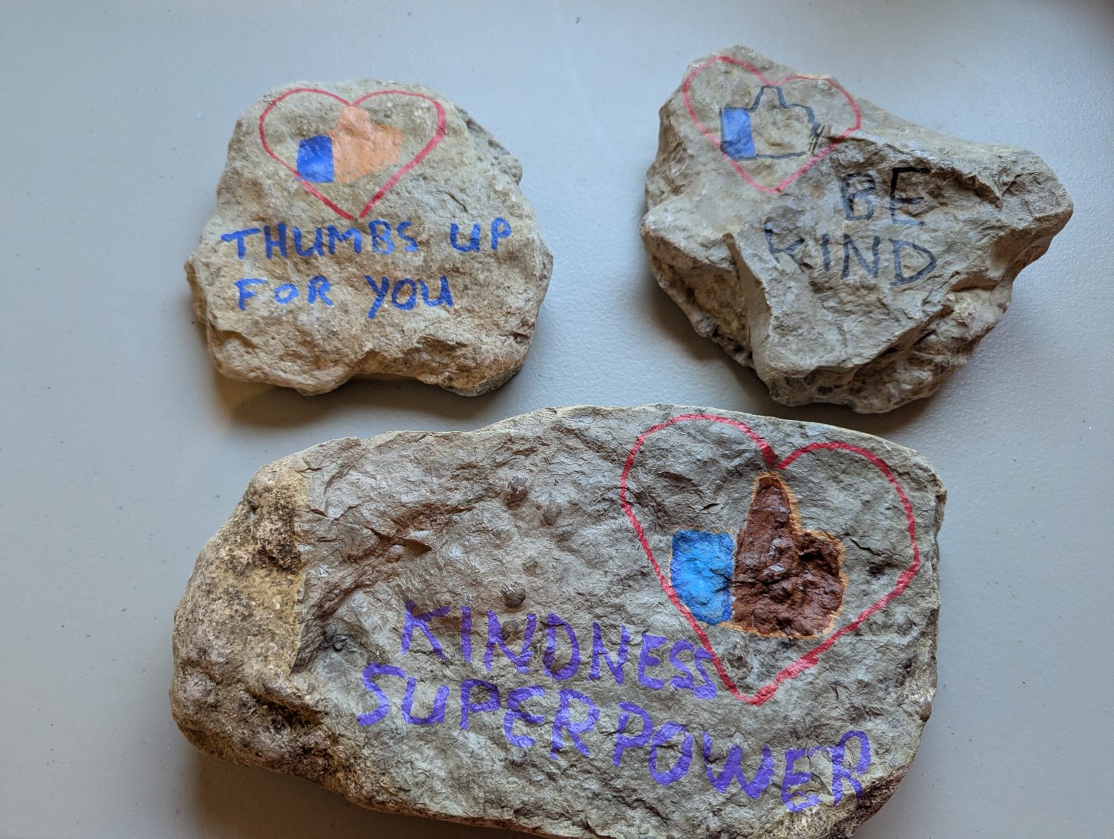 Three Kindness Rocks: Thumbs Up For You, Be Kind, and Kindness Super Power