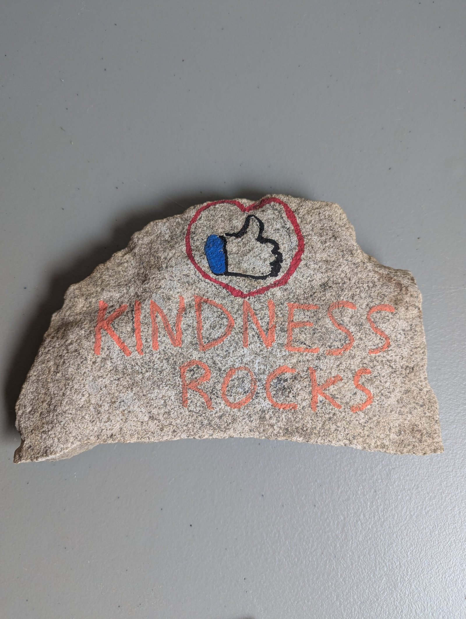 Kindness Rocks main example – thumbs up inside a heart with the words KINDNESS ROCKS