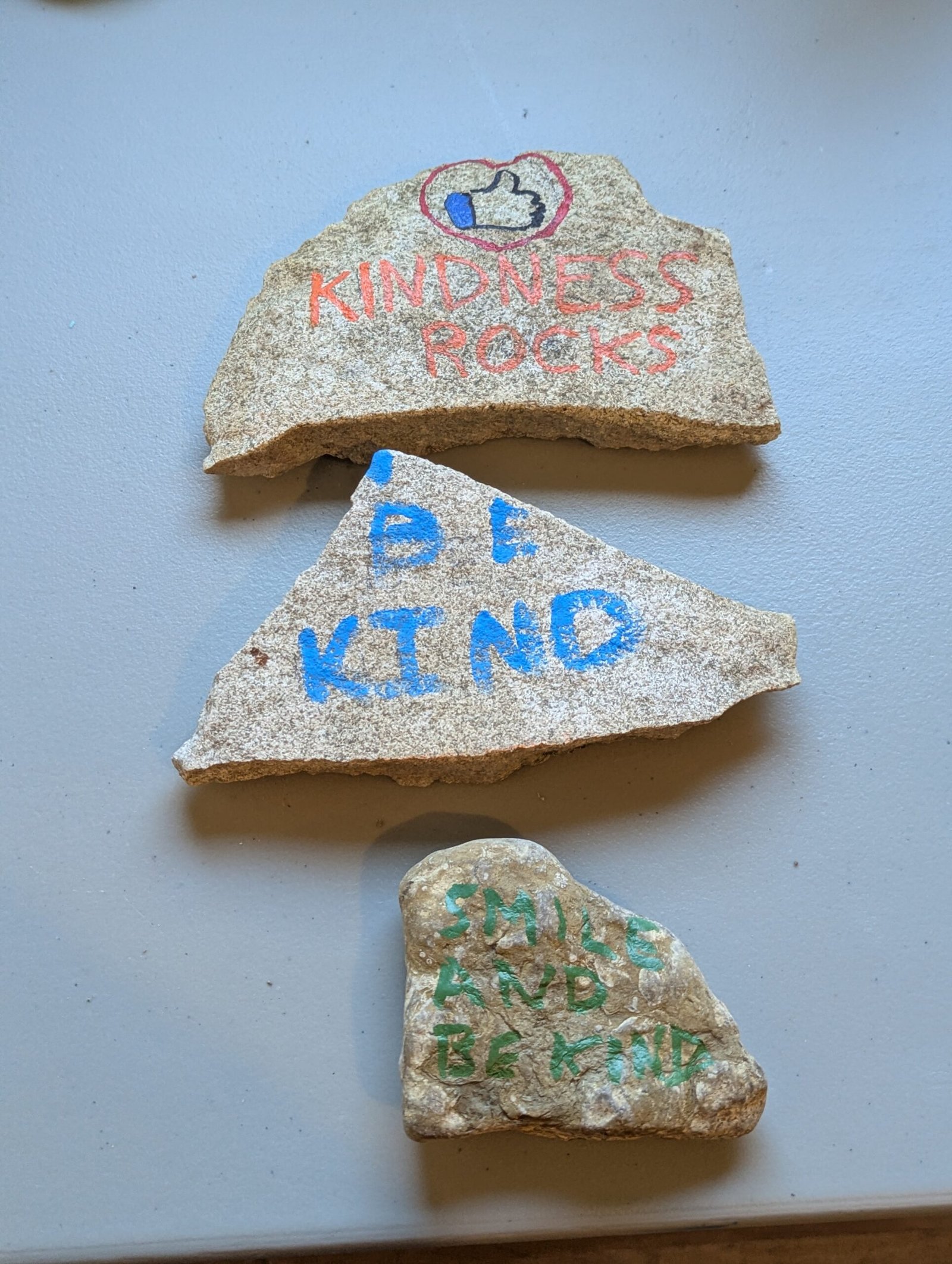 Three Kindness Rocks: Kindness Rocks logo, Be Kind, and Smile and Be Kind